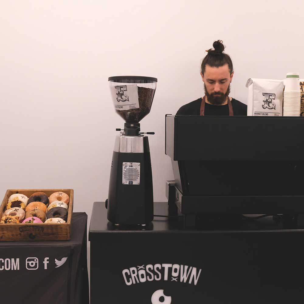Crosstown | man making coffee at a doughnut and coffee stall