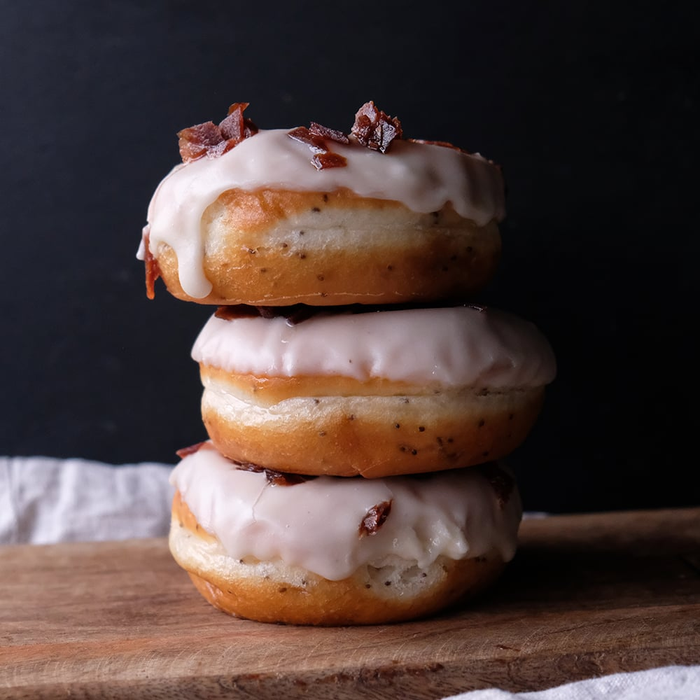 Three Vegan Bacon Doughnuts stacked on a tabletop