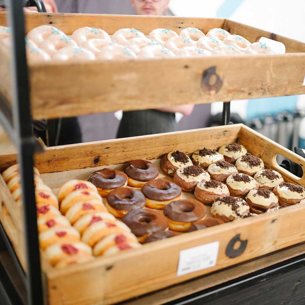 Variety of doughnuts in wooden Crosstown boxes on display