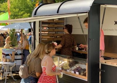 People looking at doughnuts on display in a doughnut truck